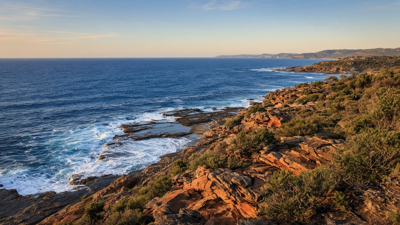 Generated view from a rocky Sapphire Coast headland over sapphire water and a wave-cut rock platform.